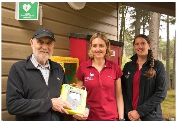 Kenneth Cooper holds a life-saving AED with Volunteer Rangers Keira Macfarland and Leo Hunt.